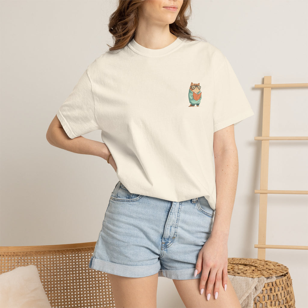"Ivory streetwear t-shirt featuring a small graphic print of a cute cat wearing glasses and reading a book."